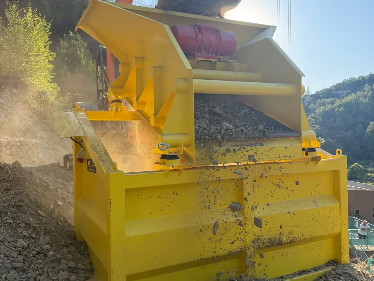 Crible compact CC120 en action sur chantier, alimenté à la pelle pour produire du criblé recyclé