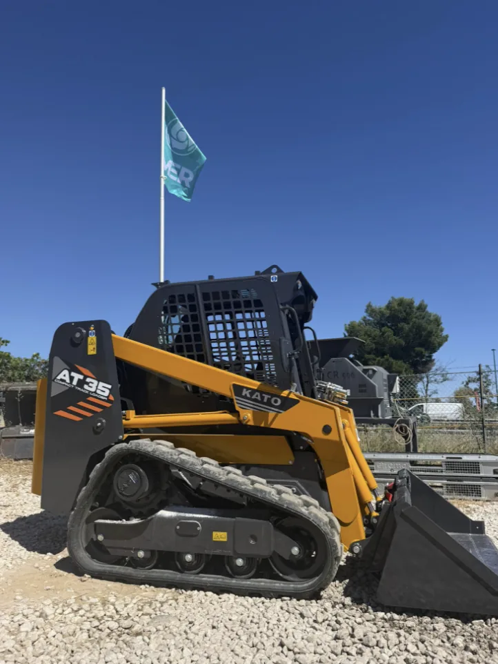 Chargeuse compacte et engins TP avec drapeau Artaud Services BTP, ciel bleu du Var